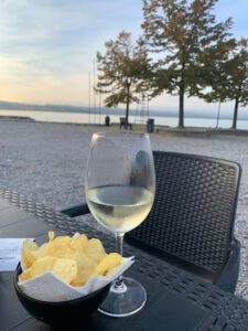 Lugana white wine glass and Lake Garda view