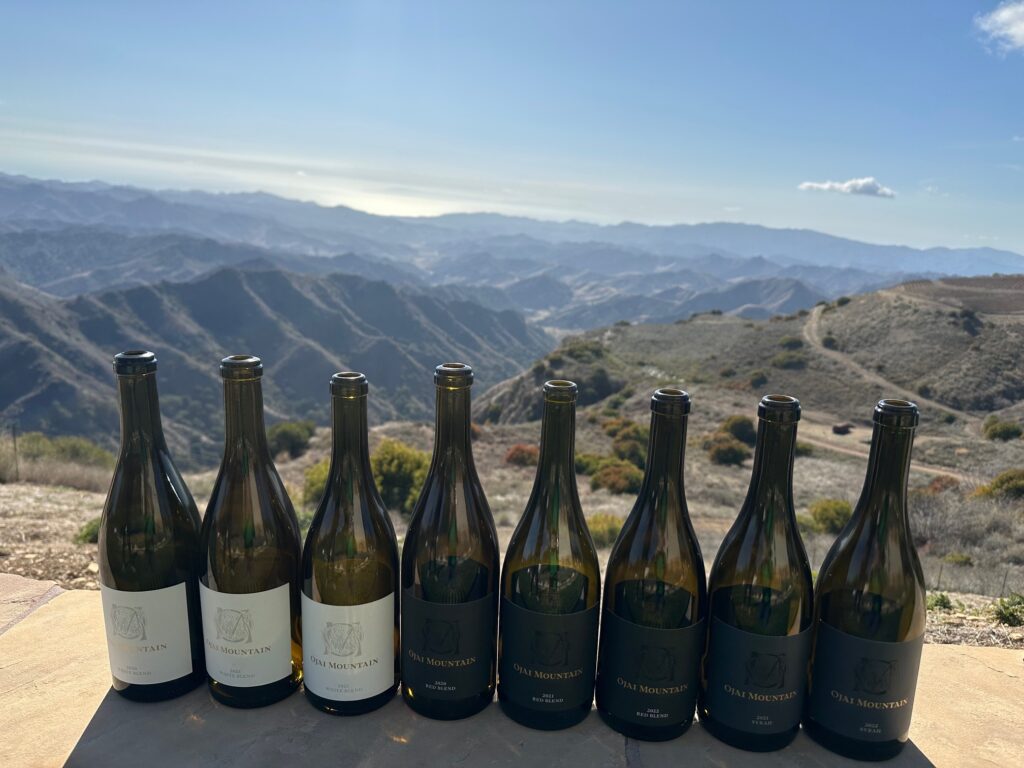 Six bottles of Ojai Mountain Estate wine on wall overlooking mountains